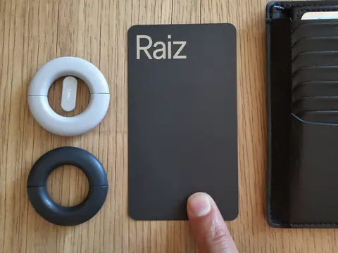 Des traceurs ronds de porte-clés à côté de la carte plate Raiz Telecom