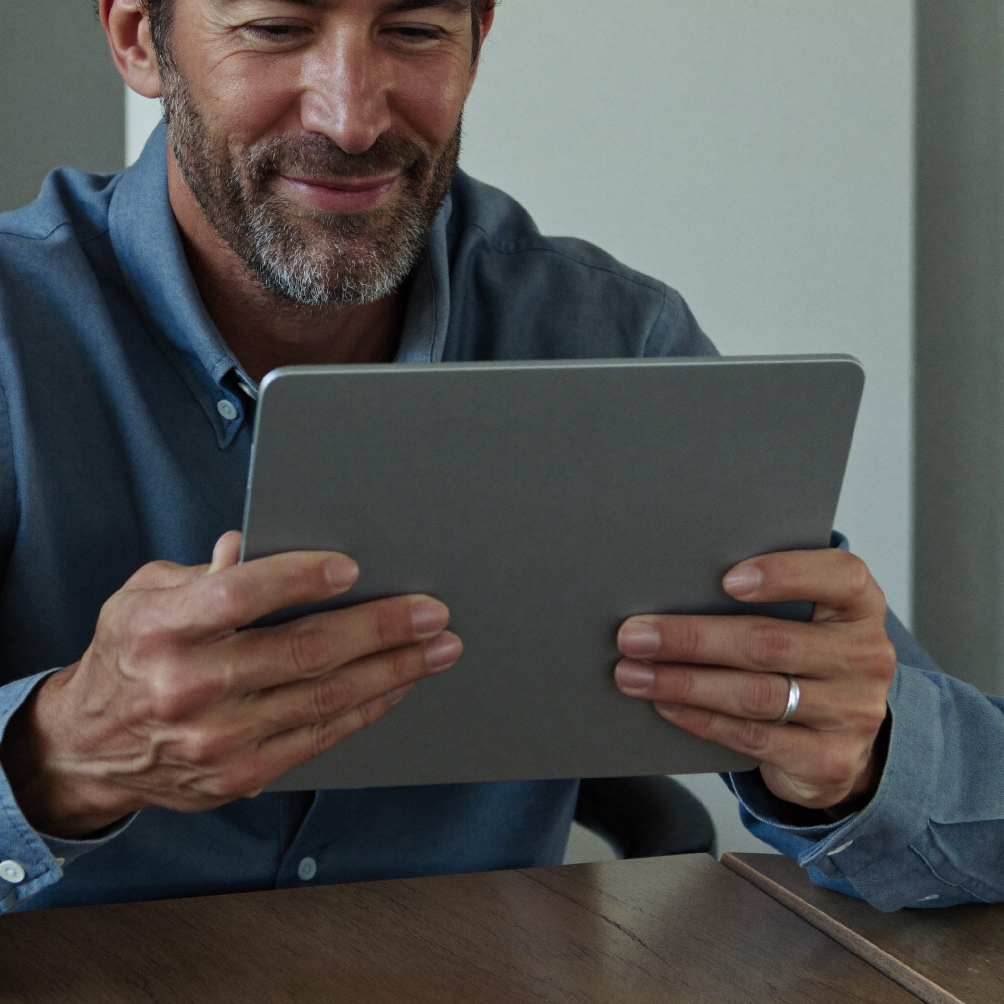 Un homme de la cinquantaine apprend à se servir de sa tablette
