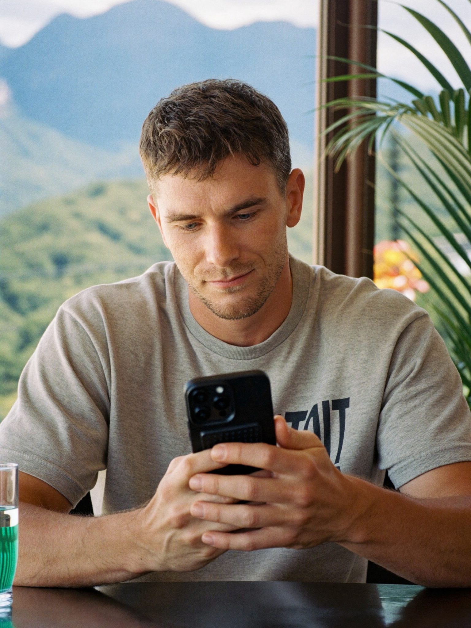 Homme d'une quarantaine d'années suivant une leçon sur son téléphone dans un café